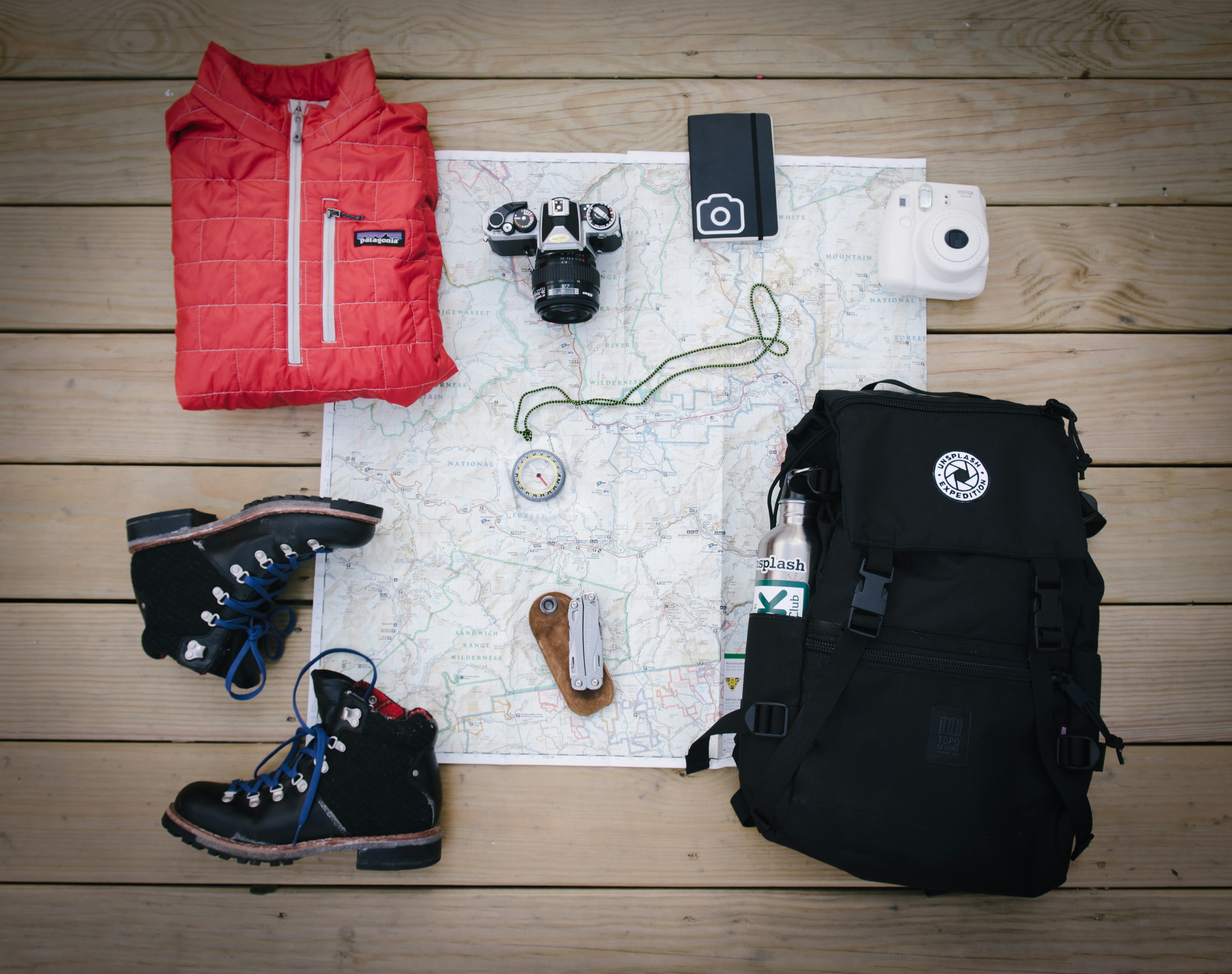 backpack, shoes, and other accessories on top of a map.